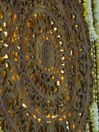 A close-up of the intricately carved wooden panels that formed the backdrop of the mandap, inspired by the art of North India and executed by artisans from Karnataka.