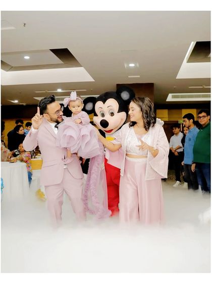 Another shot of the family enjoying a magical moment with the Mickey Mouse mascot, perfect for a first birthday celebration.