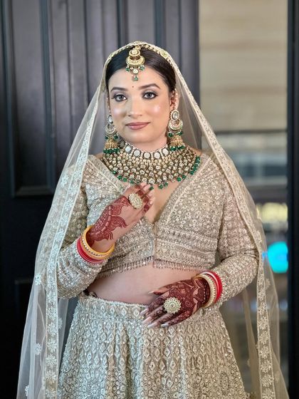 A beautiful bridal makeup demonstration, showcasing a soft glam look with a focus on radiant skin and elegant jewelry.