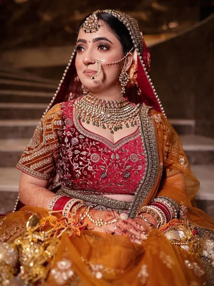 A full-length shot of the bride on the stairs, looking like a queen in her magnificent lehenga and jewellery.