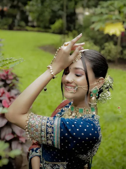 A happy, candid shot in a garden setting. The bride's natural smile and glowing makeup create a look of effortless beauty, proving that you can be both royal and relaxed.