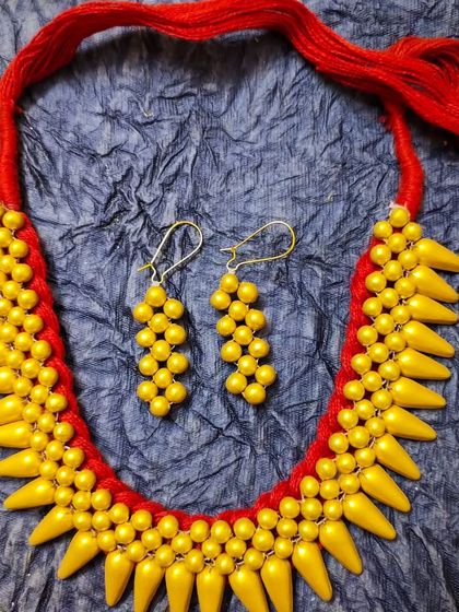 This is my unique spike choker, made from yellow terracotta beads and strung on a red thread. It's a very modern and edgy design that comes with matching beaded earrings.