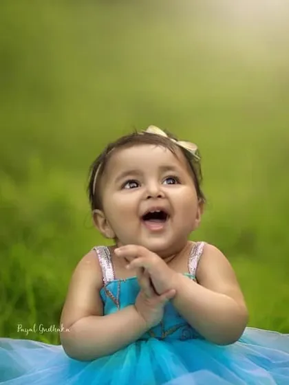 The pure, uncontainable joy of a toddler. Her happy expression and bright blue dress against the vibrant green grass show that the best photos come from letting kids just be themselves.