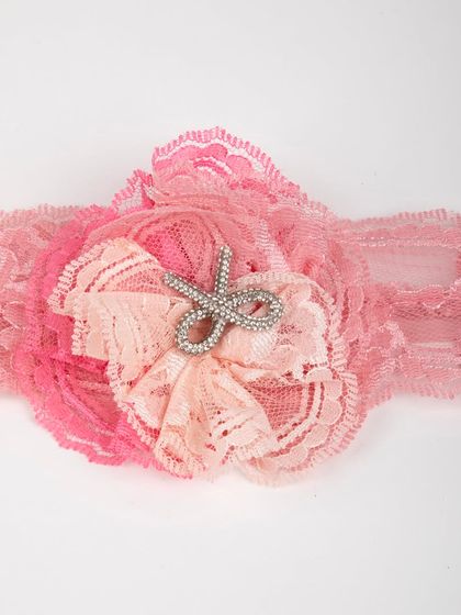 A close-up of the matching lace headband with a rhinestone scissor embellishment.