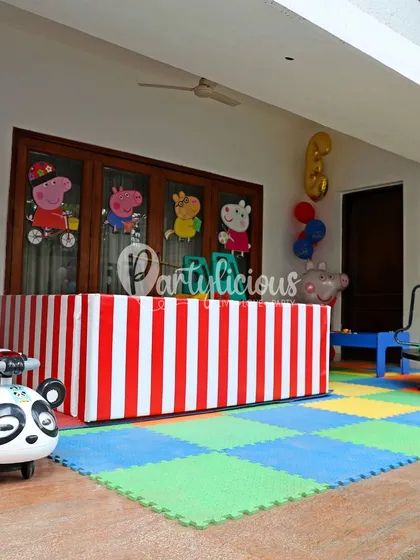 A designated play area at the Peppa Pig party, complete with soft mats and character decals on the windows.