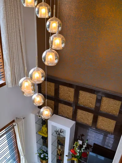 Layered lighting is one of my signature touches, demonstrated here by a stunning cascading bubble glass chandelier that descends through a double-height space. This feature not only provides illumination but also acts as a dramatic art installation, adding a touch of glamour and drawing the eye upward.