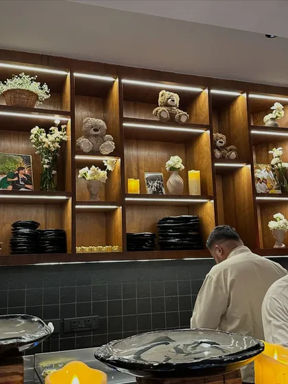 Even the food service area was part of the decor, with shelves styled with teddy bears, family photos, and soft candlelight to match the event's warm and personal theme.