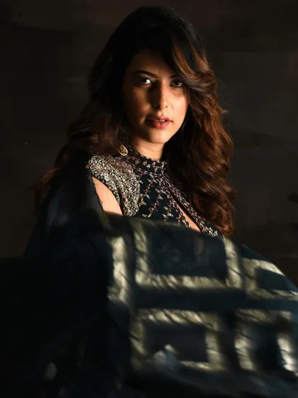 Directing this shot for an Indian couture brand, I focused on creating a dramatic and moody portrait. The styling highlights the intricate embellishments on the shoulder of this dark, elegant ensemble.
