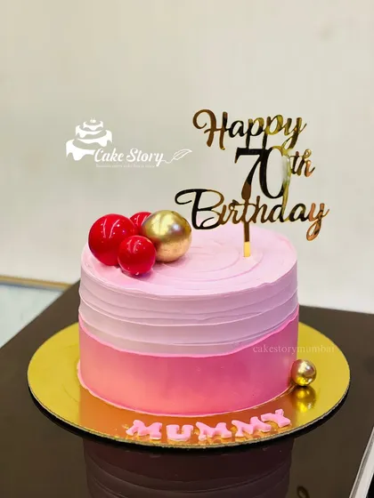 An elegant cake for a mother's 70th birthday. The pink ombre design is simple yet beautiful, topped with a 'Happy 70th Birthday' sign.