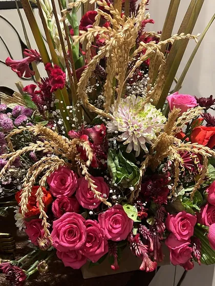 A closer look at the textures in our festive floral arrangement. The mix of fresh flowers and dried elements creates a rich and interesting visual.