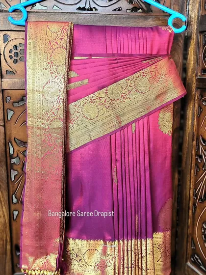 This image demonstrates hanger folding for a pre-pleated saree, an alternative to box folding for easy storage.