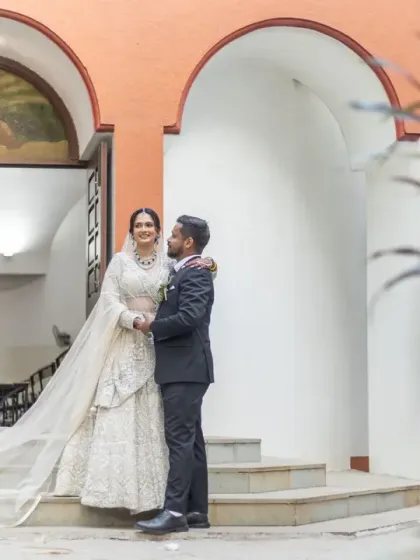 A wide shot showing the couple in the context of the beautiful church architecture, with the long veil adding a touch of elegance.