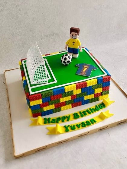 A Lego football cake for Yuvaan's birthday. The cake is designed to look like a football pitch made of Lego blocks.