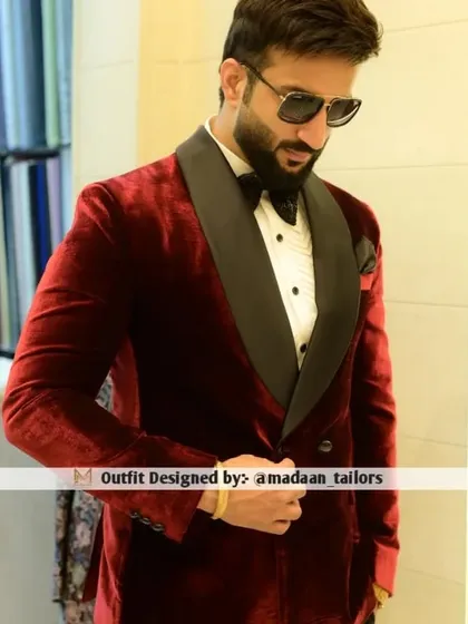 A closer look at the luxurious red velvet tuxedo. The double-breasted design and wide shawl lapel add a touch of old-school glamour to this modern piece.