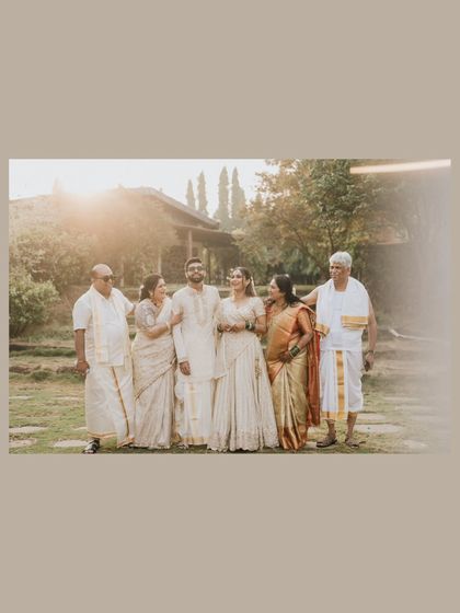 A beautiful family portrait with the couple and their parents, all dressed in elegant traditional attire, basking in the golden sunlight.