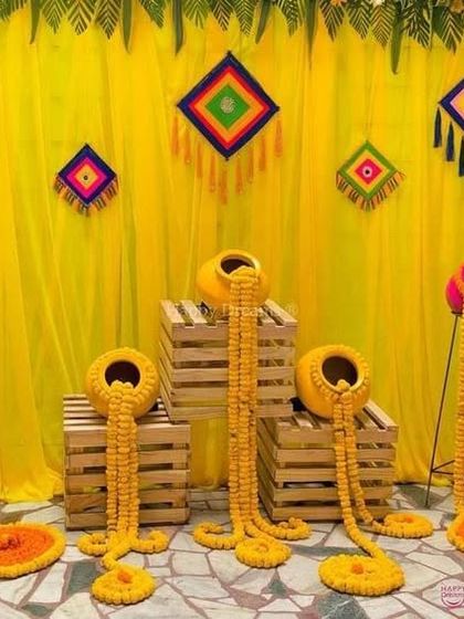 A creative way to use marigolds for a Mehndi function. I created these flowing floral arrangements coming out of traditional pots, set against a bright yellow backdrop.