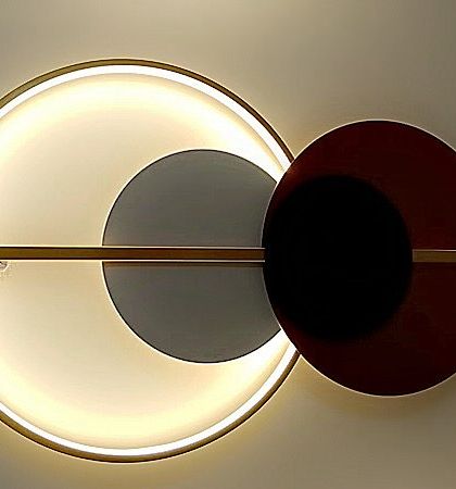 A geometric wall light inspired by celestial themes. The backlit ring and overlapping colored discs create a piece of art that also illuminates.