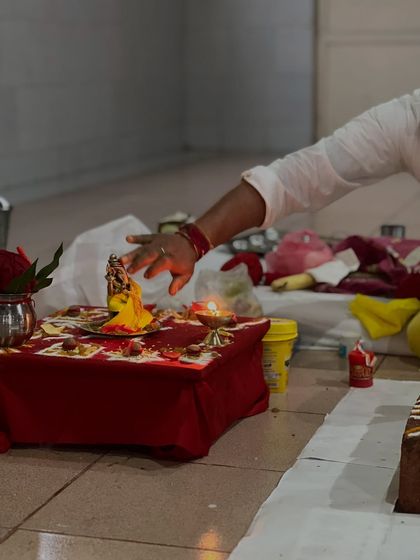 A hand reaches out to make an offering to the deity during a puja ceremony. These acts of devotion are an integral part of Bhakti Yoga.