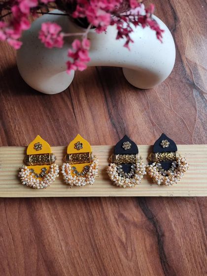 My version of the popular temple earrings. These feature a fabric top piece with a golden base adorned with pearl beads, available in both yellow and black.