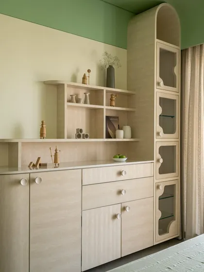 A custom credenza in Movingue veneer with soft, curved edges and simple knob pulls. The unit is part of a larger composition of built-in furniture designed to be both highly functional and sculpturally beautiful.