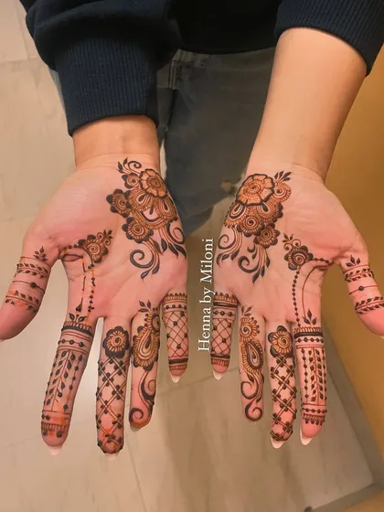 Another view of this minimal engagement mehendi. The scattered floral elements and detailed finger designs create a chic and modern look.