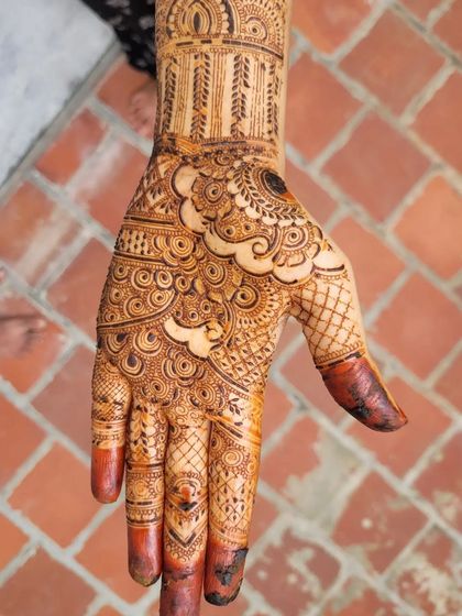 A close-up of a bridal palm design with beautiful swirls and negative space. The contrast between the filled and open areas makes the intricate details pop.