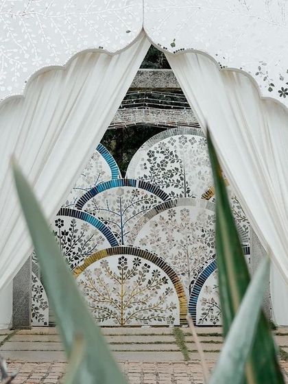 Another perspective of the Thikri entrance, framed by lush greenery. The contrast between the natural elements and the crafted mosaic highlights the beauty of both.