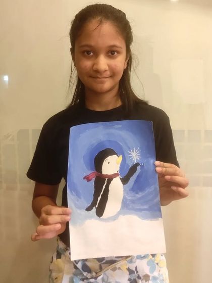 A student from our acrylics class holds up her finished penguin painting, showing great brush control.