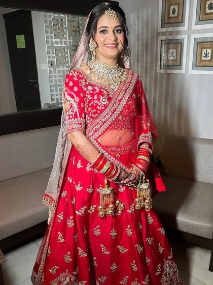 The full bridal look, showcasing the beautiful red lehenga and the flawless makeup that makes the bride feel confident and ready for her big day.