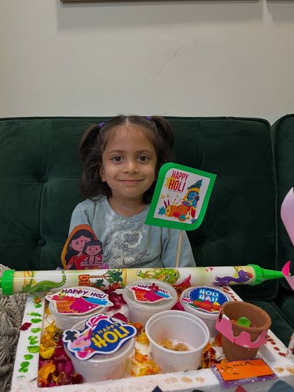A student with her complete Holi platter, including herbal colors, a pichkari, and handmade decorations.