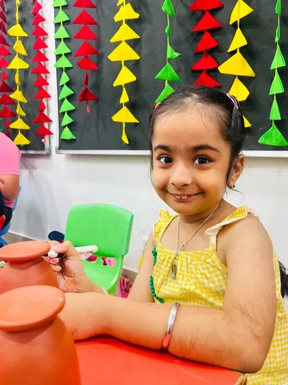 A candid shot of a student concentrating on painting her diya for the Diwali workshop.