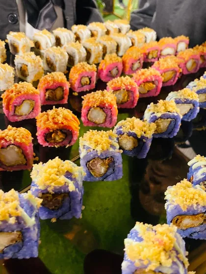 A vibrant platter of assorted sushi, including colorful prawn tempura rolls. My interactive sushi stations bring a taste of authentic Japanese cuisine to your event, prepared fresh by skilled chefs.