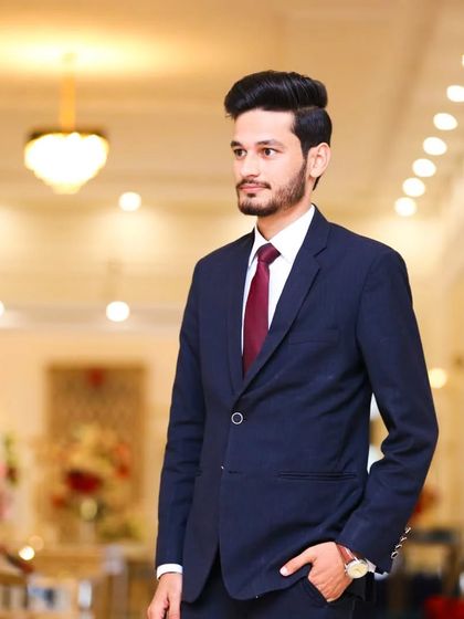 Another look at this sharp suit. The hairstyle is modern and neat, complementing the formal attire.