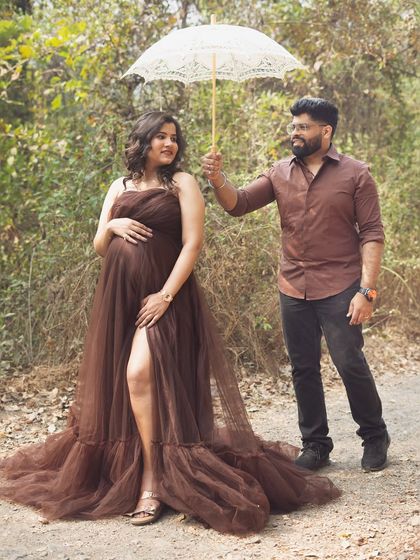 A sweet and playful moment between the couple. The husband-to-be holds the parasol for his wife, creating a charming and protective image during their outdoor shoot.