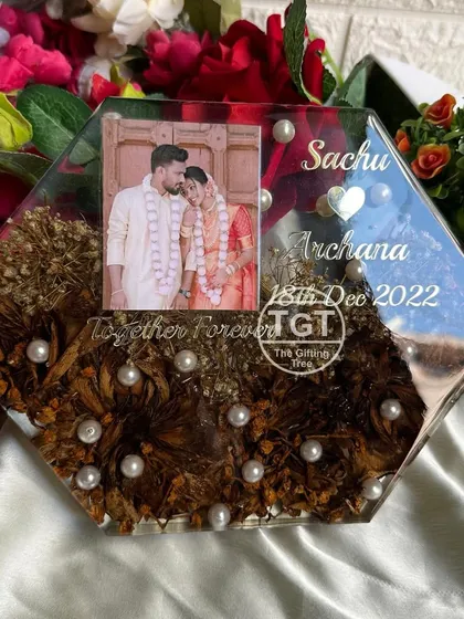 An angled view of the hexagonal frame, showing the depth of the resin and the aged color of the preserved lotus flowers.