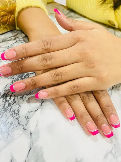 A fun and modern take on the French manicure, using a bright, hot pink for the tips and a silver glitter line for extra pop.