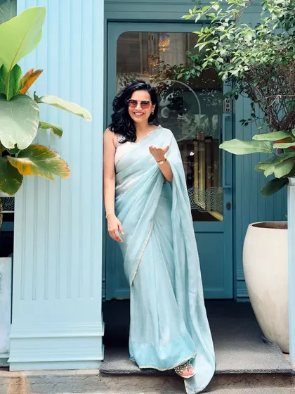A serene and elegant look in a beautiful pastel blue saree. This photo, taken against a matching blue doorway, shows my eye for color coordination and creating aesthetically pleasing fashion content.