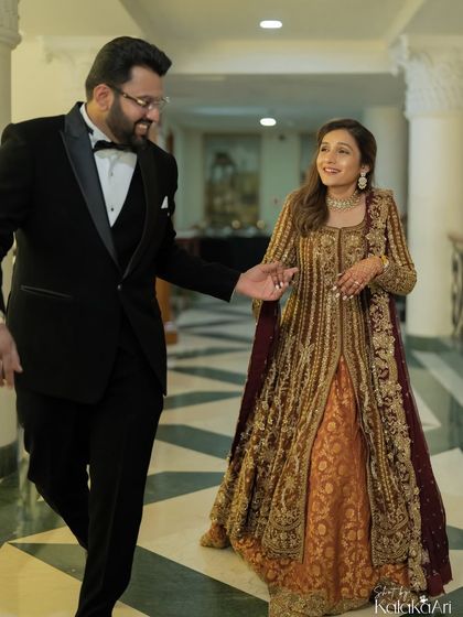 A candid moment as the groom leads his bride. Her smile and his gentle guidance make this a sweet, storytelling image.