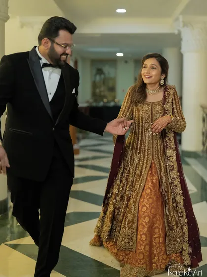 A candid moment as the groom leads his bride. Her smile and his gentle guidance make this a sweet, storytelling image.