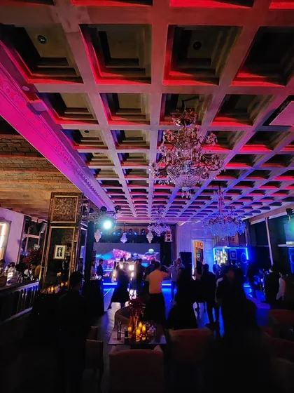 The ambiance of an indoor cocktail party, with dramatic red and pink lighting setting the mood. The right lighting is just as important as the music for creating a club-like feel.