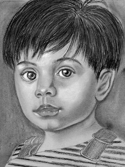 A charcoal portrait of a young boy, created on grey-toned paper. Using toned paper allows us to work with both dark charcoal and white highlights, which helps make the portrait pop and gives it a three-dimensional feel.