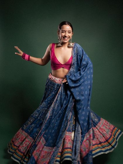 A joyful and dynamic shot of a model in a traditional ghagra. The swirling fabric and her happy expression perfectly capture the festive spirit, making it a vibrant image for a Navratri or wedding season campaign.