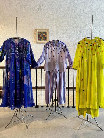 A trio of summer-ready outfits, featuring floral prints and embroidery in shades of blue, lavender, and lime green.