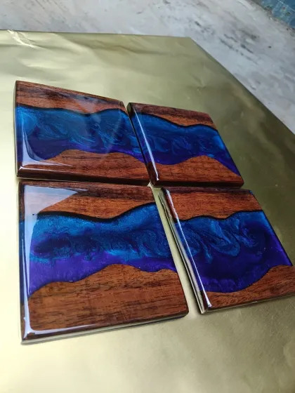 These river-style coasters combine dark wood with shimmering blue and purple resin, creating a mini version of our popular river tables.