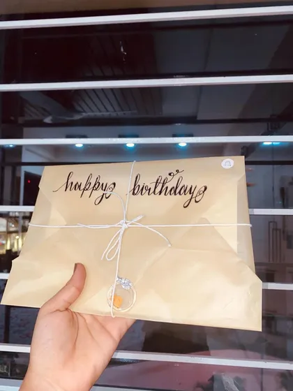 A still shot of the "Happy Birthday" vintage letter, held up to show the translucent quality of the paper and the beautiful calligraphy.