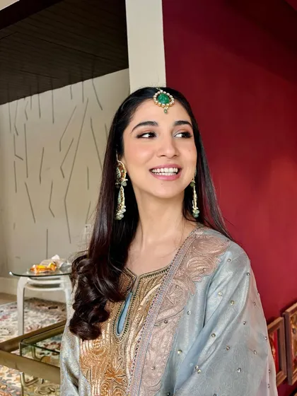 A candid moment of joy. Her makeup is fresh and radiant, perfect for a daytime event, and her smile is absolutely infectious.