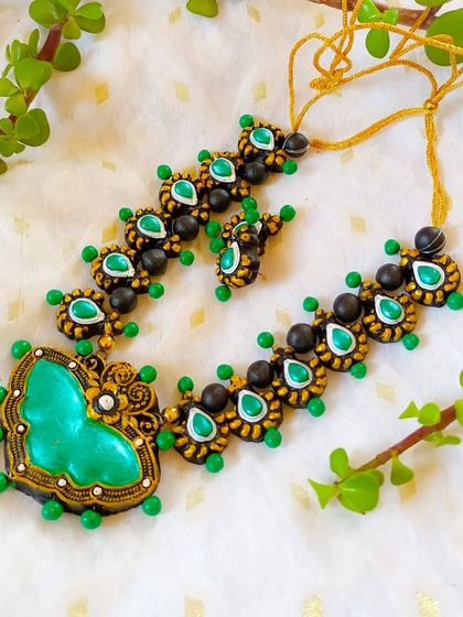 A beautiful butterfly-pendant necklace in green and black. The heart-shaped pendant and delicate chain make it a lovely piece.