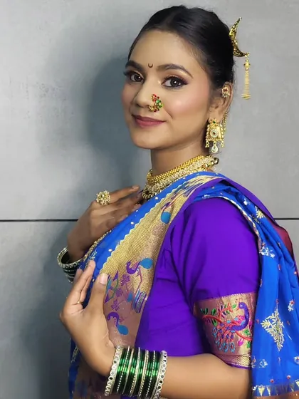 A side profile showcasing the elegant hair accessory and the drape of the Paithani saree.