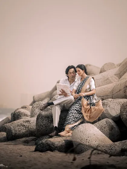 A quiet moment reading the paper together by the sea. This image is styled to feel like a memory from another time, focusing on the connection and shared peace between the couple.