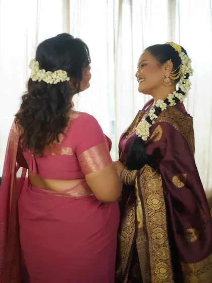 A back view showing the elegant hairstyles adorned with fresh flowers, a key element of this traditional shoot.